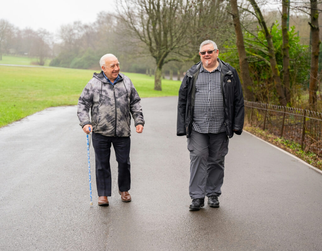 men checking phones on tennis court